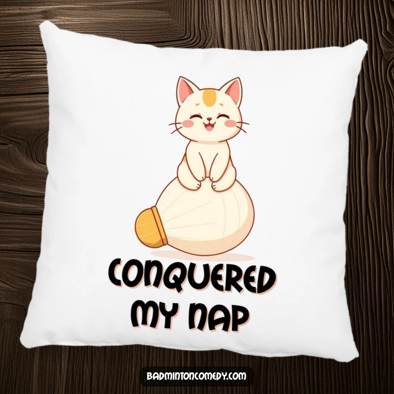Funny pillow featuring a happy cat sitting proudly atop a large shuttlecock, looking content and regal.