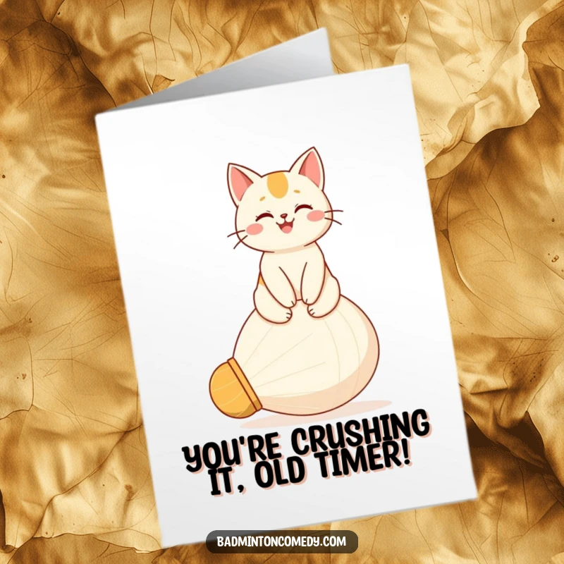 Funny Free Printable Birthday Card: Happy cat proudly perched atop a giant shuttlecock, a triumphant birthday wish.